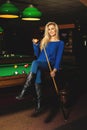 Fun sexual lady posing on pool table with the cue and ball in ha Royalty Free Stock Photo