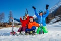 Fun on ski vacation mom and kids sit in snow with skies Royalty Free Stock Photo