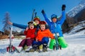 Fun on ski vacation mother and kids sit in snow with skies Royalty Free Stock Photo