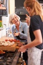 Fun times and great food. a senior woman and a young woman cooking together over a stove. Royalty Free Stock Photo