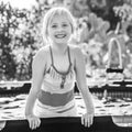 Smiling active child in swimwear playing in swimming pool