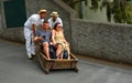 Funchal Madeira couple having downhill basket ride.