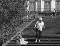 a tourist walking around an old lady begging on the steps of the historic Church of Our Lady of Monte in funchal Royalty Free Stock Photo