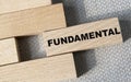 FUNDAMENTAL - word on a wooden bar on a gray background