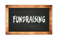 FUNDRAISING text written on wooden frame school blackboard