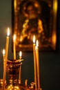 funeral candles burn on altar in front of icon