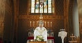 Funeral, church and priest with prayer by coffin for memorial service, sermon and ceremony for death. Religion, guidance Royalty Free Stock Photo