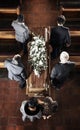 Funeral, coffin and family mourning death of loved one, death and carrying wood casket in church for faith wake, eulogy