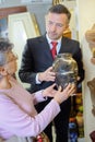 Funeral director with widow choosing urn