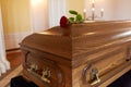 Red rose flower on wooden coffin in church