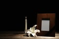 Funeral photo frame, burning candle and white lily