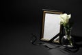 Funeral photo frame with ribbon and white rose on black background Royalty Free Stock Photo