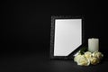 Funeral photo frame with ribbon, white roses and candle on dark table against background. Space for design Royalty Free Stock Photo