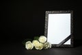 Funeral photo frame with ribbon and white roses on table against black background. Space for design Royalty Free Stock Photo