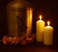 Funeral urn with praying hands and burning candles. Royalty Free Stock Photo