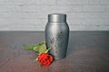 Funeral urn beside a red rose. Royalty Free Stock Photo