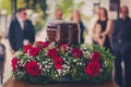 Funerary urn with ashes of dead and flowers at funeral