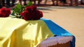 Funerary urn with ashes of dead and flowers at funeral. Burial urn decorated with flowers and people mourning in Royalty Free Stock Photo