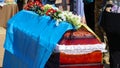 Funerary urn with ashes of dead and flowers at funeral. Burial urn decorated with flowers and people mourning in Royalty Free Stock Photo