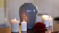 Funerary urn and candles on table burning indoors