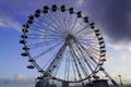 Funfair circle ferris wheel in daylight city