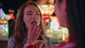 Funfair girl eat snacks at illuminated carousel closeup. Relaxed teenager talk Royalty Free Stock Photo