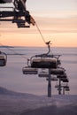 Funicular lifts/cable railway lifts. Pink sunset on top of the mountain. Snow all around, skiing resort beauty.