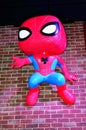 Funko Spiderman hangs from brick wall