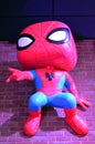Funko Spiderman hangs from brick wall