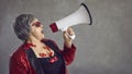 Funky eccentric senior woman yelling in a megaphone announcing a crazy blowout sale