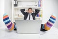 Funky socks. Happy businessman in funky socks sitting at his working place and holding head in hands Royalty Free Stock Photo