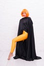 Funky style beauty. Sensual woman in fashion style on white brickwall. Fashion model wearing orange wig hair style and Royalty Free Stock Photo