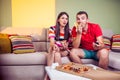 Funky young couple eating pizza on a couch Royalty Free Stock Photo