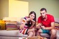 Funky young couple eating pizza on a couch Royalty Free Stock Photo