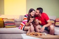 Funky young couple eating pizza on a couch Royalty Free Stock Photo