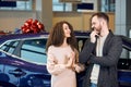 Funnny woman pressing her palms, begging her boyfriend to buy a vehicle for her