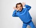 Funny active little girl dressed in sportswear having fun on a white background.