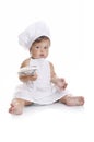 Funny adorable baby boy chef sitting and playing