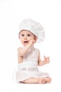 Funny adorable baby boy chef sitting and playing with kitchen equipment on a white background. Little Chef. Food banner for text