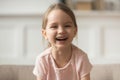 Funny adorable little girl laughing looking at camera, headshot portrait Royalty Free Stock Photo