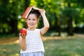 Funny adorable little kid girl with book, apple and backpack on first day to school or nursery. Child outdoors on warm