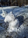 Funny and adorable melting snowman in early spring leaning to the side in sunlight, ready to fall Royalty Free Stock Photo