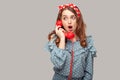 Funny amazed pinup girl ruffle blouse holding phone handset surprised by conversation, open mouth shocked Royalty Free Stock Photo