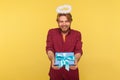 Funny angelic bearded guy with saint halo on head holding gift box, giving present and smiling kind friendly, donation