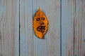 A funny angry smiley emoticon face drawn on a yellow golden leaf Royalty Free Stock Photo