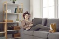 Funny angry woman sitting on sofa with laptop and reading nasty comments on social media