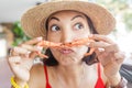 Asian girl makes a moustache out of fresh shrimp. Concept of Mediterranean cuisine and delicious seafood Royalty Free Stock Photo