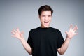 Funny asian guy in black t-shirt and short hair fooling around and acts like a bear roar Royalty Free Stock Photo