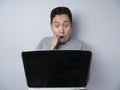 Funny Asian man shocked when Looking at His Laptop Royalty Free Stock Photo