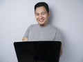 Funny Asian Man Working on His Laptop, Smiling Expression